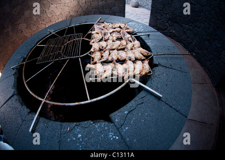 Essendo il pollo cotto sulla griglia sopra il vulcano Lanzarote Foto Stock