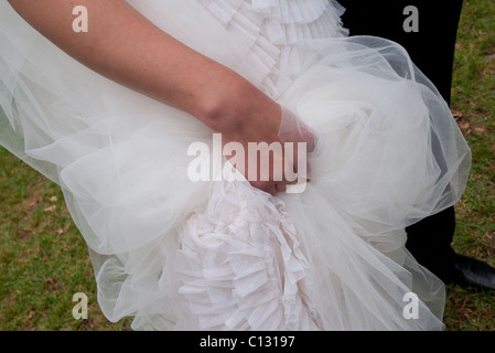 Sposa tenendo il suo abito Foto Stock