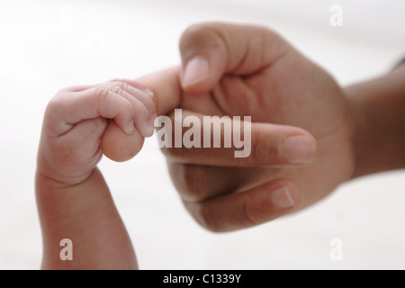 La madre e il bambino la ragazza (0-1 mese) tenendo le dita, Cape Town, Provincia del Capo Occidentale, Sud Africa Foto Stock