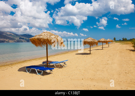 Spiaggia e lettini su Agrostoli baia vicino a Lixouri, CEFALLONIA, ISOLE IONIE, Grecia. Foto Stock