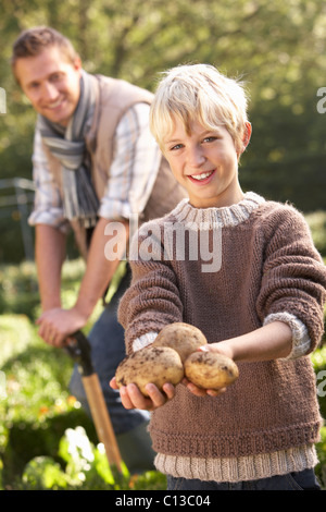 Giovane uomo con bambino lavora in giardino Foto Stock