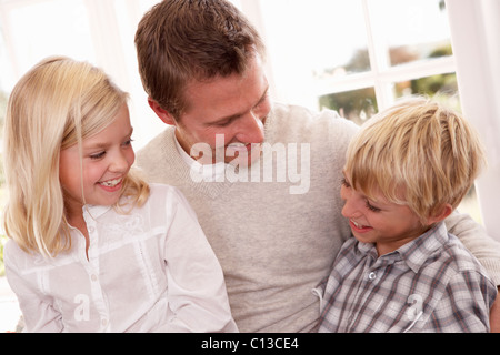 Uomo e bambini pongono in studio Foto Stock