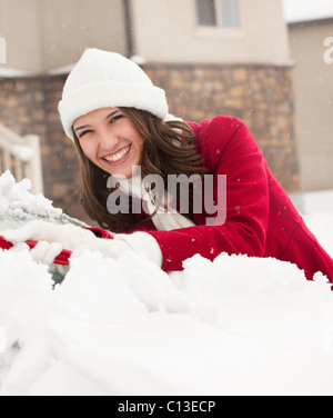 Stati Uniti d'America, Utah, Lehi, Ritratto di giovane donna la raschiatura di neve da auto Foto Stock