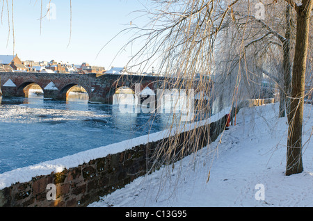 Vista di Auld Brig Dumfries città e del Fiume Nith in nevoso inverno condizioni Foto Stock