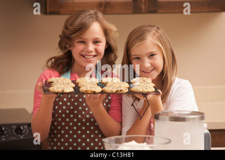 Stati Uniti d'America, Utah, Lehi, ritratto di due ragazze (10-11) azienda biscotti in cucina Foto Stock