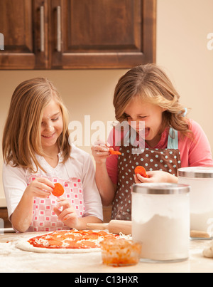 Stati Uniti d'America, Utah, Lehi, due ragazze (10-11) preparare la pizza in cucina Foto Stock