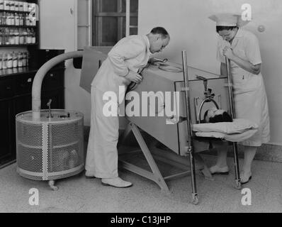 La poliomielite paziente in un polmone di ferro al Scots Mission Hospital di Tiberiade, Palestina nel marzo 1940. Quando la polio muscoli indeboliti utilizzati nella respirazione, un polmone di ferro, attaccato ad una grande pompa aria, respirazione assistita. Foto Stock