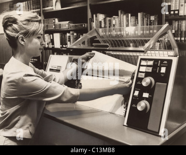 Bibliotecario tenendo una stampa da un UNIVAC 490 stampante. Negli anni sessanta la tecnologia del computer è stato disponibile per gli specialisti in questo caso per la gestione di cataloghi di biblioteche e circolazione del libro. 1966. Foto Stock