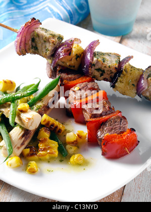 La carne di maiale e ananas peperoncino e spiedini di carne di manzo con mais e palm insalata di cuore Foto Stock