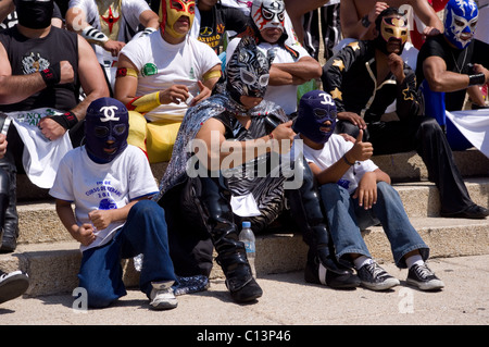 Luchador messicano (wrestler) con due bambini durante la sfilata di un corteo in città del Messico Foto Stock