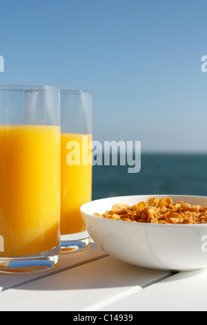 Bicchieri di succo di arancia e di una ciotola di cereale dal mare. Foto Stock