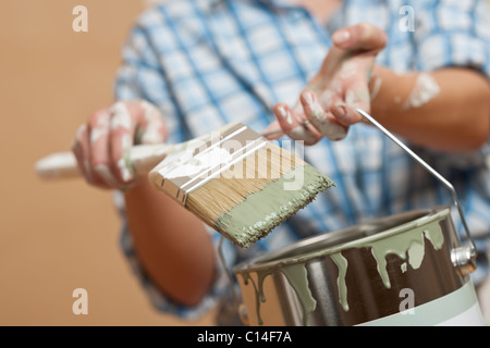 Miglioramento di casa: Donna holding spazzola di vernice e la vernice può Foto Stock