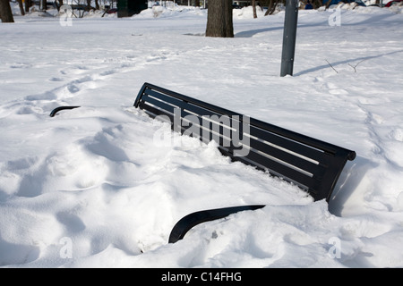 Una panchina nel parco sepolto nella neve, Helsinki Finlandia Foto Stock