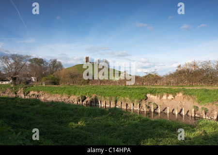 Vista del Burrow Mump in prima serata, con il fiume Parrett nuovi membri in primo piano. Foto Stock