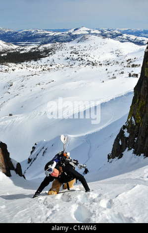 Una femmina di sciatore si inerpica su per una ripida couloir in inverno vicino a Carson passano nella Sierra Nevada, CA. Foto Stock