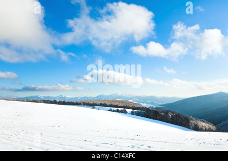 Ottobre mountain foresta di faggio il bordo con il primo inverno Neve e ultimo fogliame di autunno sul versante lontano (Carpazi, Ucraina) Foto Stock