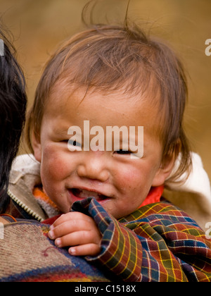 Giovane madre tibetana in Bhutan con il suo bambino sulla schiena Foto Stock