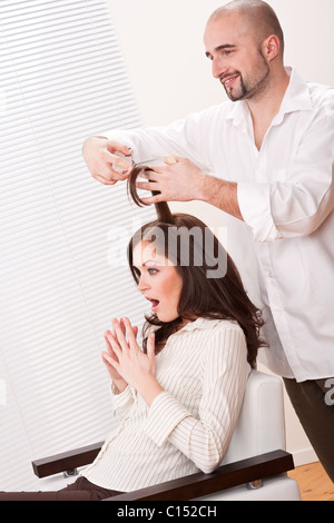 Maschio professionale parrucchiere tagliato con forbici a salon, cliente ottenendo un nuovo taglio di capelli Foto Stock