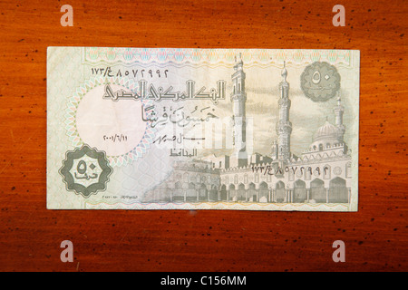 50 egiziano Piastres nota di valuta sul tavolo con scrittura araba e moschea Foto Stock