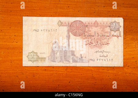 Un egiziano lira sterlina britannica nota sulla tavola con scrittura araba e moschea Foto Stock