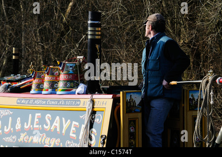 Man tenere un occhio vigile sul modo in avanti mentre la navigazione del suo canal boat vicino a Sutton Cheney in Leicestershire Foto Stock