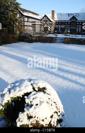 Gawsworth Old Hall, Inghilterra. Nevoso inverno vista di Gawsworth giardini e il west elevazione di Gawsworth Old Hall. Foto Stock