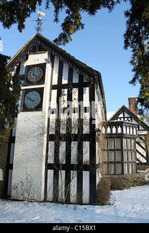 Gawsworth Old Hall, Inghilterra. Nevoso inverno vista di Gawsworth giardini e il west elevazione di Gawsworth Old Hall. Foto Stock