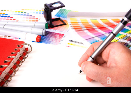 La progettazione grafica e i campioni di colore e le penne su una scrivania Foto Stock