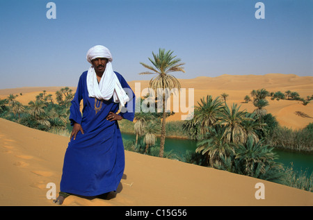 Il Tuareg uomo in piedi accanto a Um el Ma Lago, Awbari laghi, Mandara laghi, Libia, Nord Africa Foto Stock