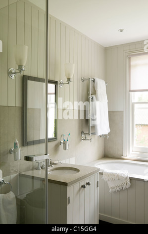 Tutte le stanze da bagno di colore bianco con pannelli di legno e muro applique lampade Foto Stock