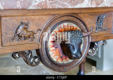 Dettaglio del scolpita testa di toro sul tavolo in legno con piano in marmo Foto Stock