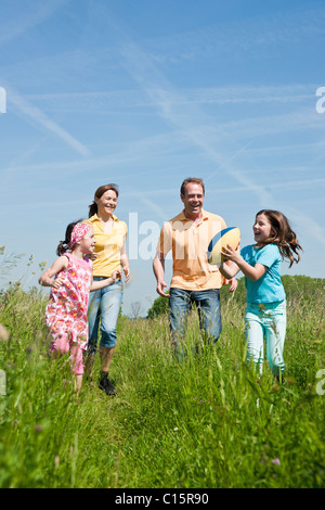 Famiglia gettando calcio su un prato Foto Stock