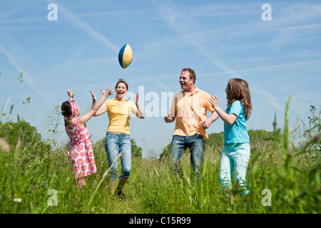 Famiglia gettando calcio su un prato Foto Stock