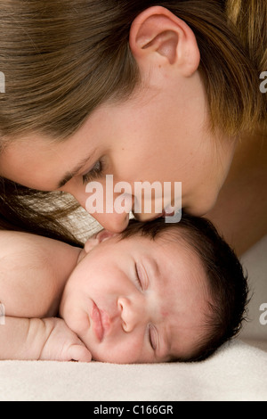 Madre bacia sleeping neonato, due settimane Foto Stock