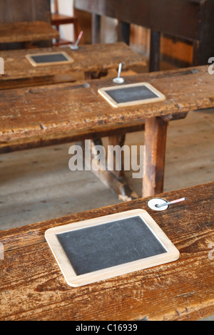 Antica aula tradizionale con panche di legno e ardesia compresse Foto Stock