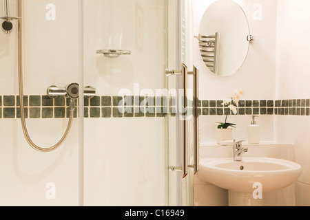 Con piastrelle bianche Bagno con specchio, vasca da bagno e doccia Foto  stock - Alamy