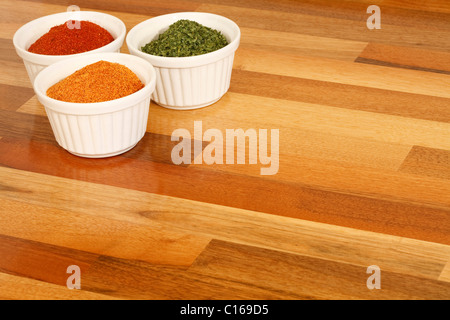 Bocce di spezie su una cucina in legno piano di lavoro Foto Stock