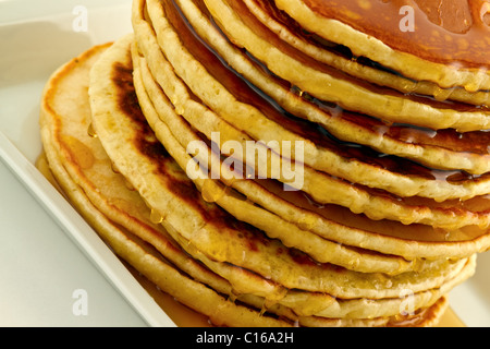 Pila di Pancake fatti in casa con sciroppo su una piastra bianca. Foto Stock