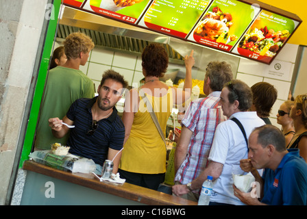 Barcellona, Spagna - Luglio 28, 2008: persone baying e mangiare cibo spazzatura al piccolo bar sulla strada della Ramblas. Foto Stock