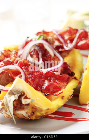 Shish kebab e pancetta croccante servita sulla buccia di ananas Foto Stock