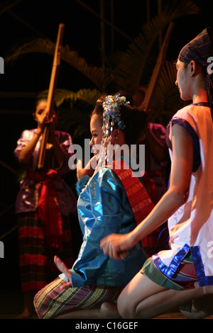 Uomini e donne che indossano tradizionali costumi tailandesi sono performanti a Krabi Dance Festival di Krabi, in Thailandia. Foto Stock