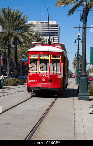 Red trolley car in pista su Canal Street in downtown New Orleans, Louisiana Foto Stock