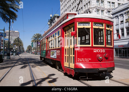 Red trolley car in pista su Canal Street in downtown New Orleans, Louisiana Foto Stock
