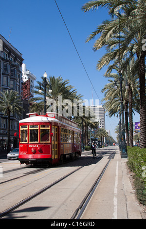 Red trolley car e bicicletta sulle tracce su Canal Street in downtown New Orleans, Louisiana Foto Stock