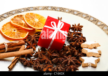 Regalo di natale, anice stellato, bastoncini di cannella ed essiccato fette di arancia su una piastra Foto Stock