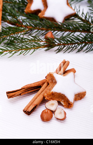 A forma di stella cannella i biscotti con rami di abete, bastoncini di cannella e hazlenuts Foto Stock