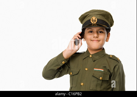 Ragazzo in uniforme della polizia a parlare su un telefono mobile Foto Stock