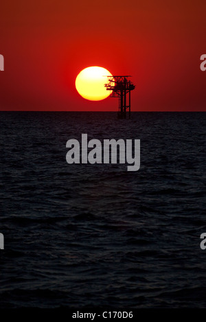 Energia solare o olio? Piattaforma di olio vicino a Galveston in Texas, al tramonto nel Golfo del Messico. Foto Stock