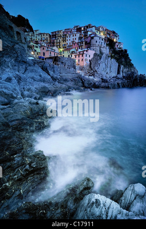 Onde che si infrangono dal villaggio di Manarola nella luce della sera sul robusto ripida costa in Liguria Cinque Terre Foto Stock