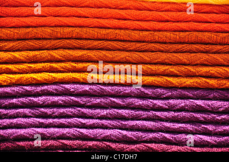 Pila di tessuti tradizionali tessuti alpaca coperte in arancione e viola Foto Stock